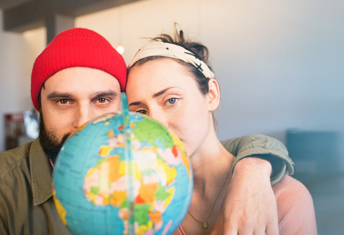 happy-young-man-and-woman-with-globe-choosing-place